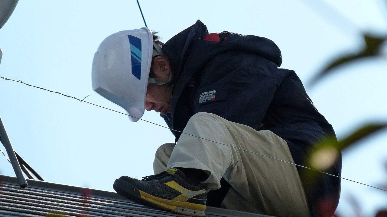 Solar installation technician on rooftop (5392894792)